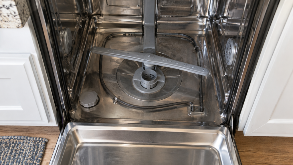 The open interior of a dishwasher tub showing the heating element at the bottom.